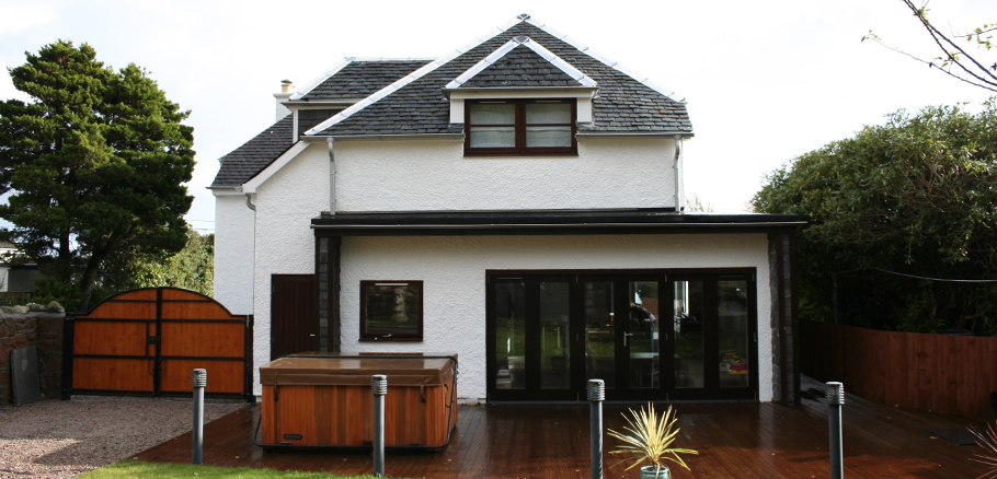 Rear facade of extended cottage with sliding folding doors, sauna and outdoor jacuzzi